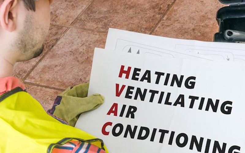 Image of a man holding a HVAC sign