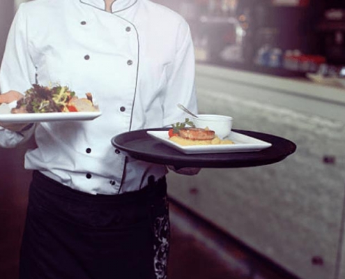 Image of a chef carrying plates of food